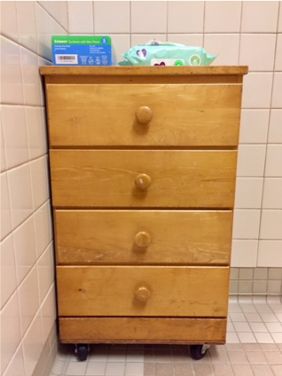 Rolling cabinet with drawers and changing supplies on the top 