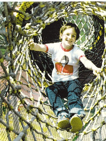 Smiling child inside a rope tunnel