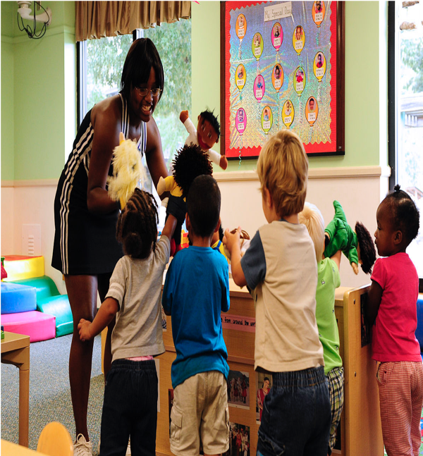 Teacher with puppets and a groud of five preschoolers in an early childhood classroom