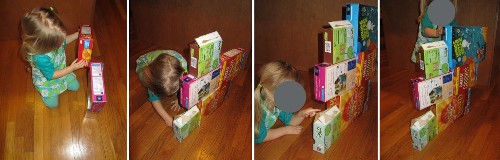 A child building a wall out of cereal boxes.