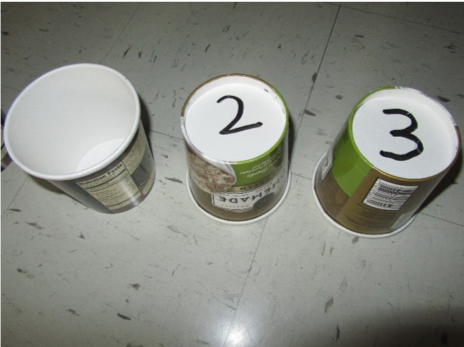 Recycled round ice cream containers with numbers written on the bottom