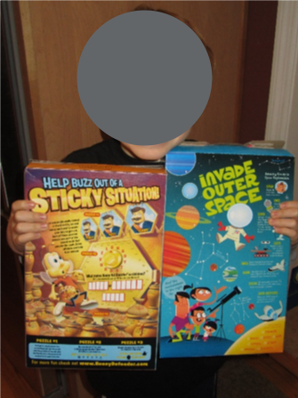 Child holding two recycled cereal boxes to compare size