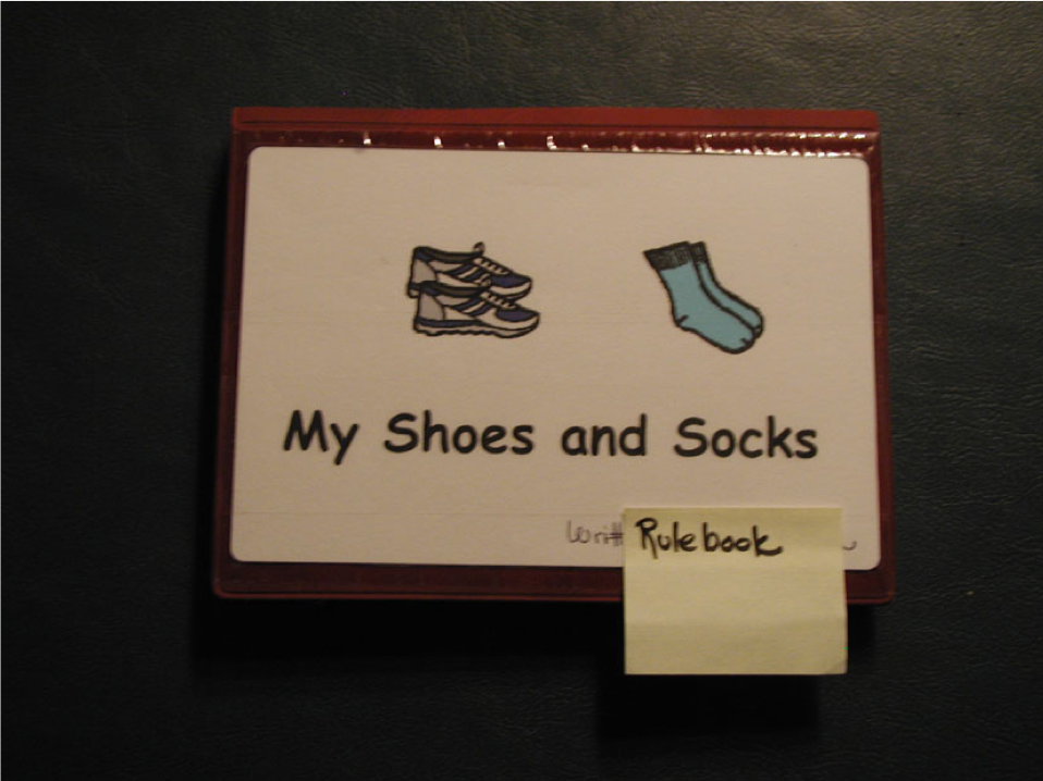A laminated bound rulebook titled My Shoes and Socks with drawing of socks and shoes. 