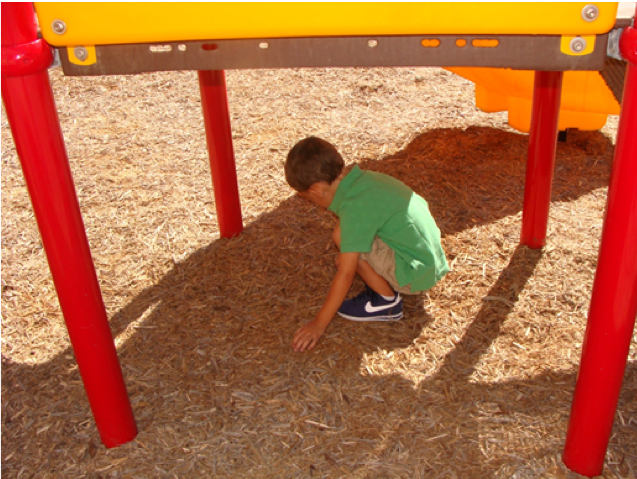 Boy under playground equipment