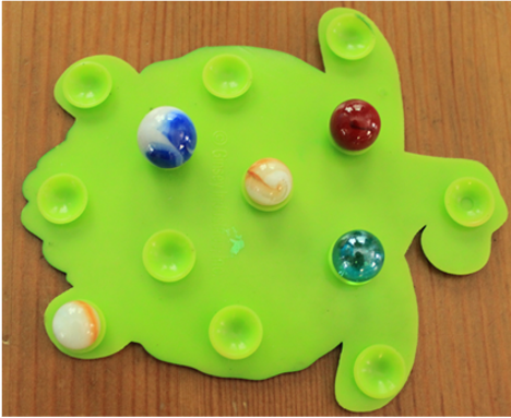 Marbles on a mat with suction cups.